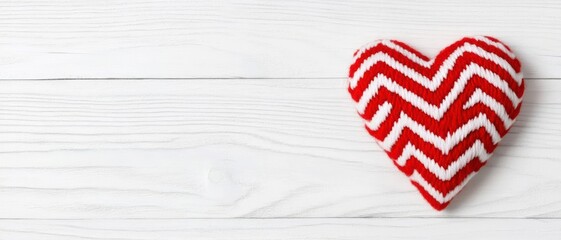 Obraz premium Red and white chevron heart decoration on a rustic wooden surface, perfect for Valentine's Day.