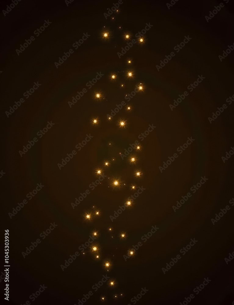 Poster warm golden garland lights glow on a dark background with a sparkly glitter effect.
