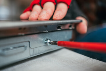 Technician carefully repairs a laptop motherboard in a workshop, showcasing expertise in electronics maintenance