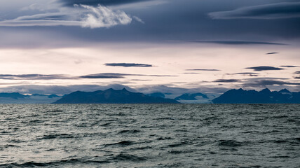 Stunning view of Svalbard\'s remote coastline under dramatic cloudy skies at dusk