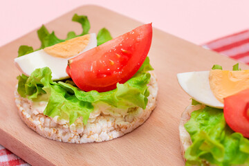 Rice Cake Sandwiches with Tomato, Lettuce and Egg on Wooden Cutting Board. Easy Breakfast. Diet Food. Quick and Healthy Sandwiches. Crispbread with Tasty Filling. Healthy Dietary Snack