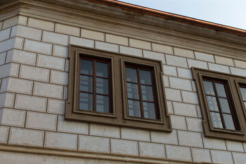 A sturdy brick building featuring two windows thoughtfully positioned on its side, showcasing the craftsmanship of brickwork and architectural design