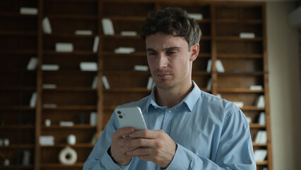 Sad adult Caucasian man businessman male guy student employee user holding mobile phone gadget frustrated bad news error problem broken smartphone losing wifi loss job online game business fail indoor