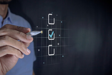 Hand holding a pen ticking a blue checkmark on a box on virtual screen. Assessment, questionnaire,...