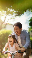 photo of an Asian father helps young daughter ride a bicycle.