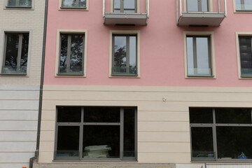 There is a pink building that features an abundance of windows and numerous balconies, making it a striking sight in the neighborhood