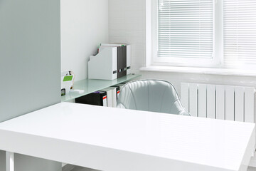 Interior of modern medical office with doctor's workplace and big window