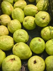 Fresh Green Guavas Displayed in a Basket for Sale at a Market Stall