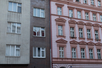 There is a pink building situated adjacent to a brown building, creating a vibrant contrast in the urban setting they share