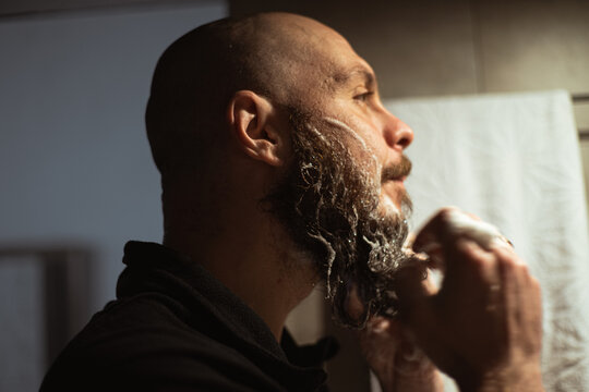 Washing beard. Man washing his beard with foam. Beard care