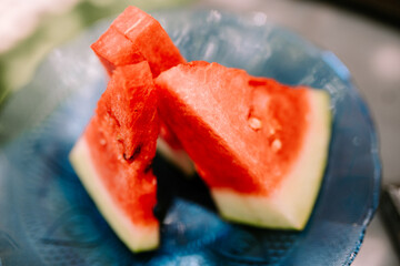 Sliced watermelon served on a plate, showcasing fresh, juicy red fruit with green rind