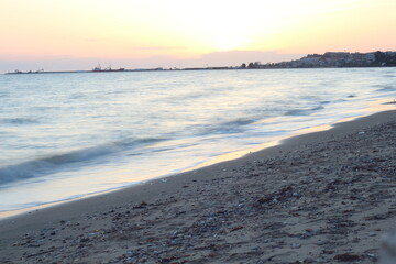Sunset casts a warm, golden glow on the sea and sand
