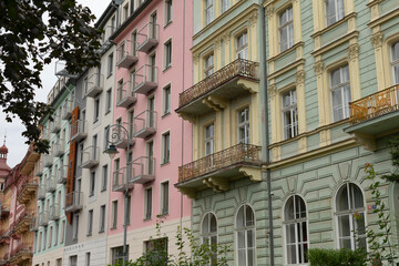 A picturesque row of buildings featuring balconies and fire escapes located in a bustling city environment, showcasing urban architecture