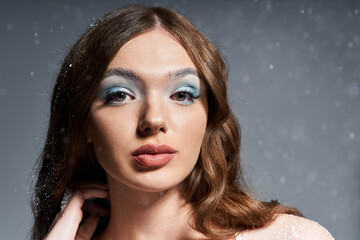 A young woman poses gracefully, showcasing her captivating features and winter inspired makeup.