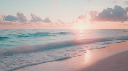 A soft pink sunrise casts a golden glow over the calm turquoise ocean waves gently lapping on a pristine white sandy beach.