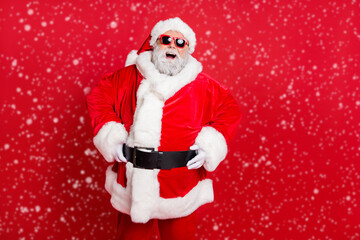 Portrait of his he nice attractive cheerful cheery positive bearded Santa having fun enjoying leisure dream vacation present gift isolated over bright vivid shine red background