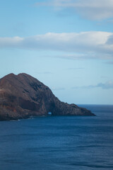 Naklejka premium Rocky Cliff Archway Emerging from Ocean