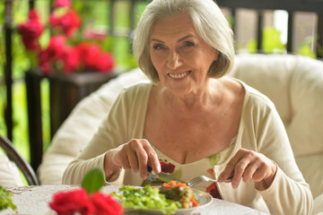 Portrait of a beautiful elderly woman dining outdoors