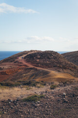 Rugged Hillside with Dirt Path and Distant Ocean
