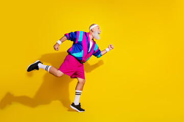 Full length photo of cheerful positive mature guy dressed retro sport jacket running race emtpy...