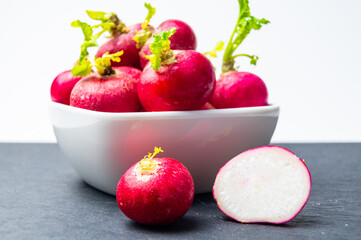 Radishes, freshly picked and placed in a white bowl.
