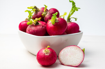 Radishes, freshly picked and placed in a white bowl.