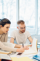 Obraz premium Diligent multiracial students doing research together in library