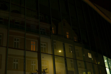 A large building featuring numerous windows is beautifully illuminated at night, creating a...