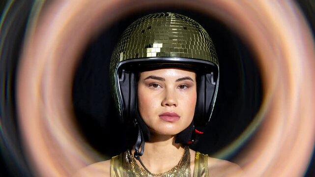 woman poses seated in sofa with discoball helmet