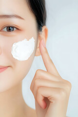 Close-up of an Asian woman's hand pointing to her face and white cream. Images for product promotions and advertisements.