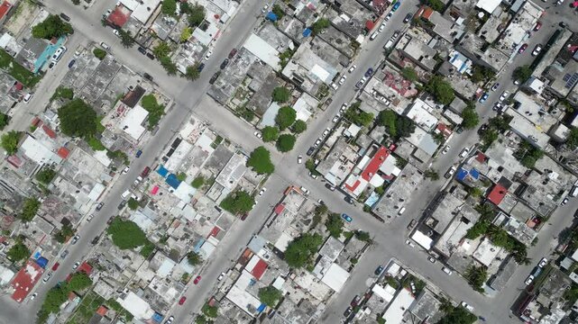 Aerial top-down view high altitude of slum, a heavily populated urban informal settlement characterised by substandard housing and squalor poor living conditions streets and rusty metal home roof tops