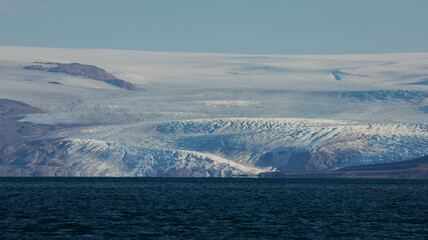 Nordenskiold Glacier glistening under sunlight with calm waters in Svalbards unique landscape