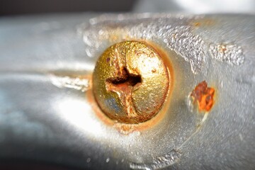  a close-up of a rusty bolt head, where corrosion has visibly taken over the metal surface.