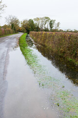 A drainage ditch overflowing after heavy rain in a lane near the village of Clanfield, Oxfordshire,...