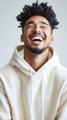 Fototapeta premium A man with a beard and a smile on his face is wearing a white hoodie