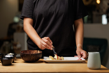 Waitress preparing a bowl of apple smoothie in the cafe kitchen.