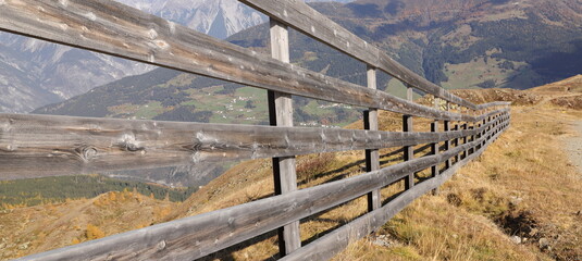 Fototapeta premium a wooden fence on a path in the mountains