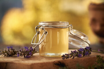 A jar of herbal syrup with fresh lavender flowers