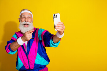 Photo of handsome good mood senior guy oldschool sportswear pointing tacking selfie modern gadget...