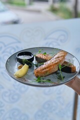 Chef Garnishing Grilled Fish with Herbs
