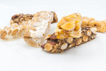 Different types of turrón (nougat), a traditional Christmas sweet in Spain, isolated on a white surface.