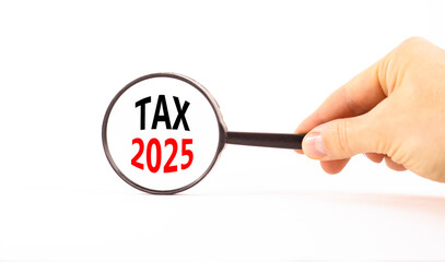 Planning tax 2025 new year symbol. Concept words Tax 2025 on beautiful white paper in magnifying glass. Businessman hand. Beautiful white background. Business tax 2025 new year concept. Copy space.