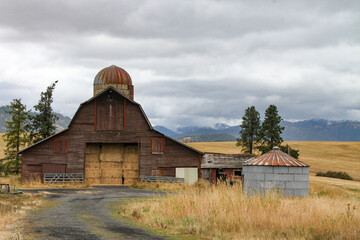 photo of vintage hay barn full of large square hay bales with a large silo attached and various other farm related buildings  © Kathy