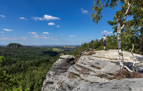 Adventurous Woman in Hiking Gear Gazes from Rauenstein Rocks Toward Pirna City in Saxon Switzerland National Park on a Summer Day, with Scenic Views and Natural Beauty Surrounding