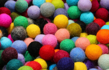 background of colorful compressed wool balls perfect for creating necklaces by piercing them with a needle