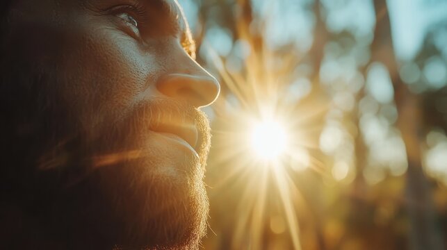 A contemplative man looks thoughtful as sun rays illuminate his face, evoking a sense of introspection and hope, set against a softly blurred nature background.