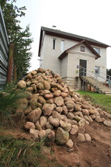 a large pile of different stones against the backdrop of a house
