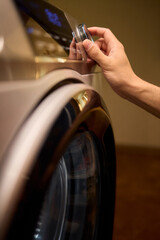 Hands Skillfully Adjusting the Washer Control in a Modern Domestic Laundry Room Environment