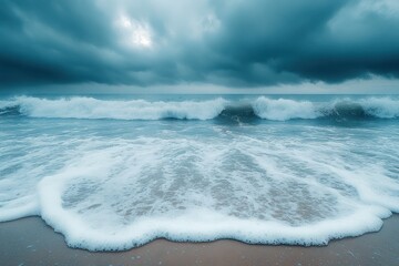 A serene coastal scene with waves gently crashing on the shore under a moody sky.