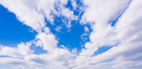 White clouds in the blue sky. Wide angle cloudy sky